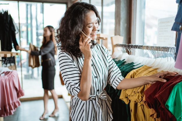 Femme asiatique, achats, choisir, quelques vêtements