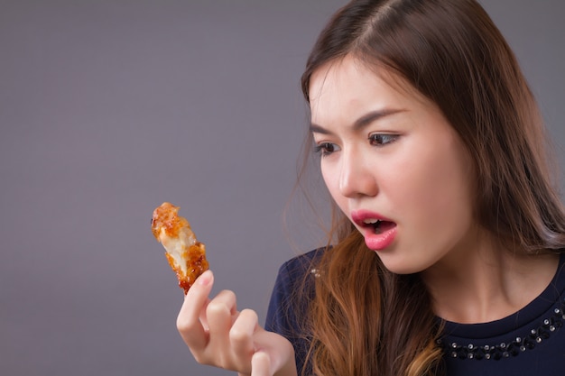 Femme asiatique affamée, manger du poulet frit