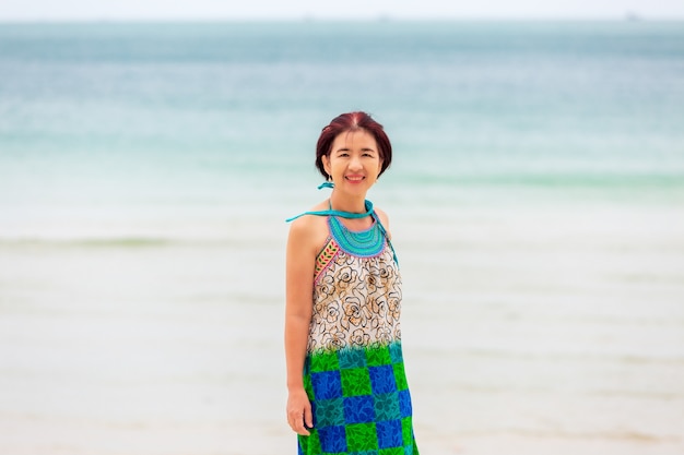 Femme asiatique d'âge moyen se reposant sur la plage de chaweng à koh samui, en Thaïlande.