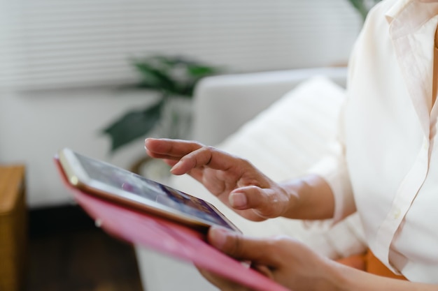 Femme asiatique d'âge moyen tenant un téléphone portable femme âgée avec téléphone intelligent femme âgée utilisant un smartphone à la maison avec concept technologique