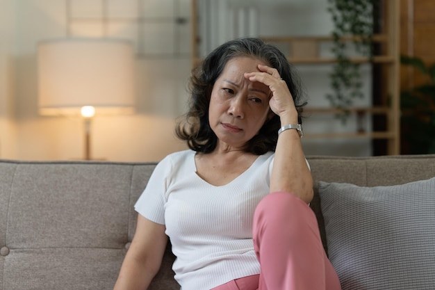 Femme asiatique âgée déprimée assise seule à la maison Concept de femme à la retraite