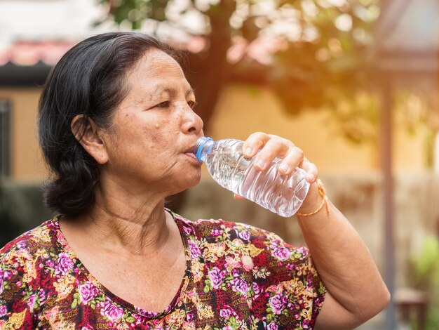 La femme asiatique âgée l&#39;eau potable de la bouteille