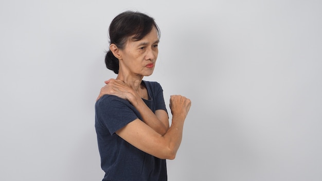 Une femme asiatique âgée ou plus âgée avait une posture de mal de dos sur fond blanc.