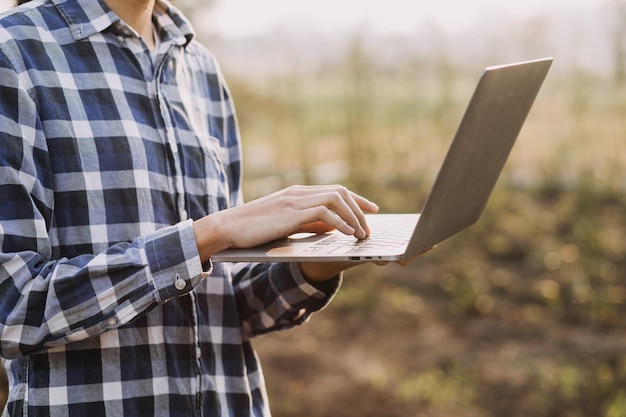 Une femme asiatique et un agriculteur travaillant ensemble dans une ferme de légumes à salade hydroponique biologique à l'aide d'une tablette inspectent la qualité de la laitue dans un jardin à effet de serre Agriculture intelligente