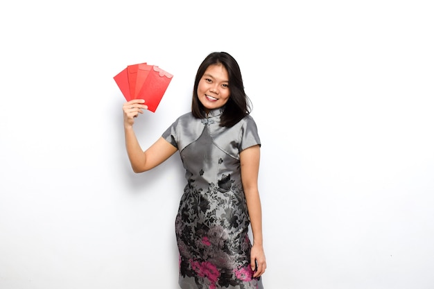 Femme asiatique à l'aide de Cheongsam traditionnel montrant et tenant une enveloppe rouge Angpau Donnez-la vous