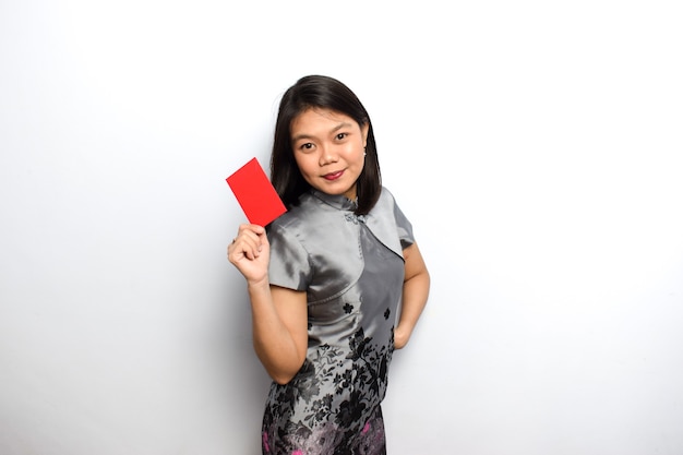 Femme asiatique à l'aide de Cheongsam traditionnel montrant et tenant une enveloppe rouge Angpau Donnez-la vous