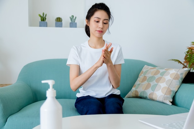 Femme asiatique à l'aide de désinfectant pour les mains en gel alcoolisé