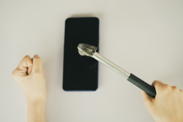 Femme Asiatique à L'aide D'un Marteau Pour Casser Son Smartphone