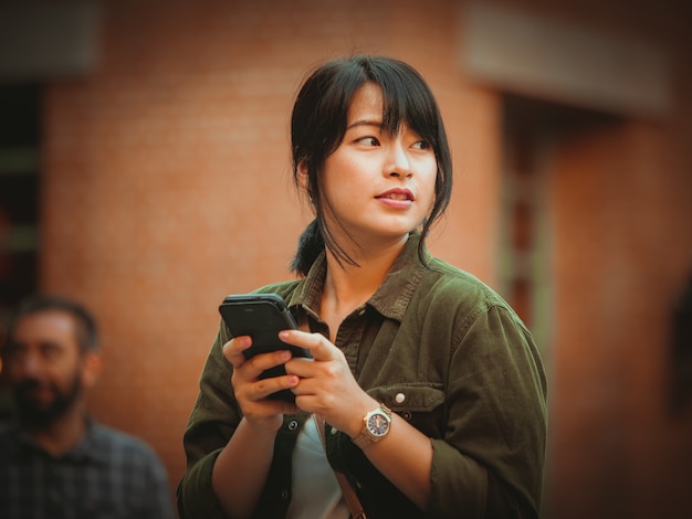 Femme asiatique à l&#39;aide de smartphone avec bonne humeur au centre commercial