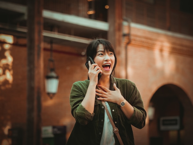 Femme asiatique à l&#39;aide de smartphone avec bonne humeur au centre commercial