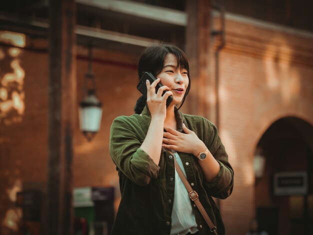 Femme asiatique à l&#39;aide de smartphone avec bonne humeur au centre commercial