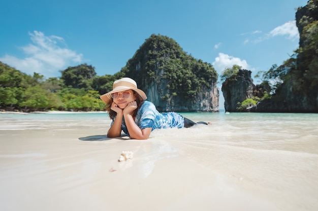 Femme asiatique allongée sur la plage.