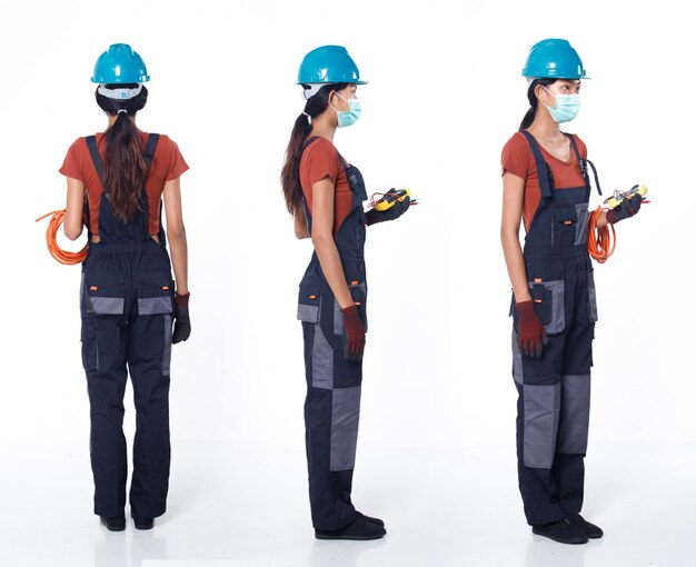 Une femme asiatique des années 20 porte un casque et un gant de chemise orange uniforme bleu en tant que réparateur électrique avec câble. Toute la longueur du grand support femelle tenir le multimètre de tension de nombreuses poses, fond blanc isolé