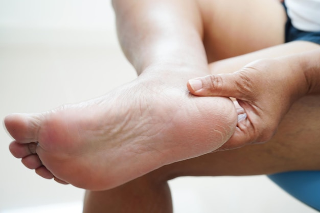 Photo une femme asiatique appliquant une crème hydratante pour soigner la peau pour résoudre et réparer les pieds avec du crack