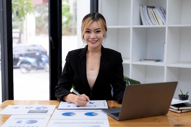 Femme asiatique assise dans un bureau privé, c'est une jeune femme d'affaires, une dirigeante, une femme asiatique qui consent à être une dirigeante et une dirigeante, une femme qui travaille. Concept de femme d'affaires.