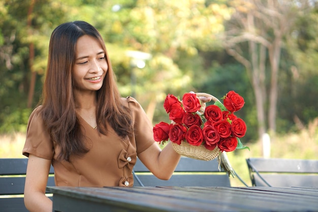 Femme asiatique assise sur une table souriant joyeusement