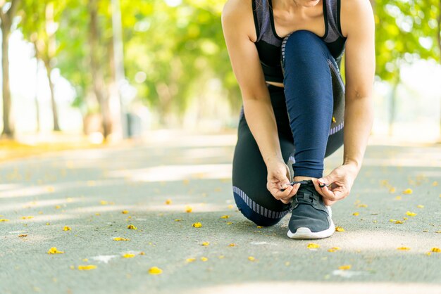 Femme asiatique attachant des lacets et se préparant pour le jogging en plein air