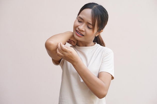 Femme asiatique ayant un bras qui démange