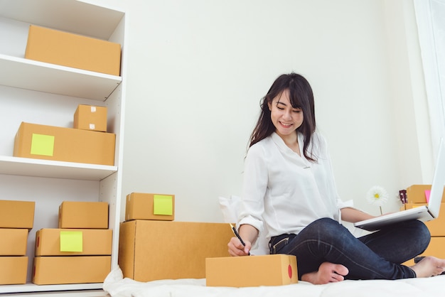 Femme asiatique de beauté à l&#39;aide d&#39;ordinateur portable et démarrer entrepreneur de petite entreprise