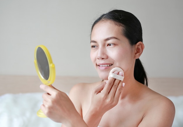 Femme asiatique de beauté se maquiller avec Sponge Powder Puff