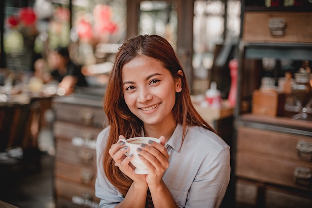 Femme asiatique, boire du café au lait au ton vintage de couleur café
