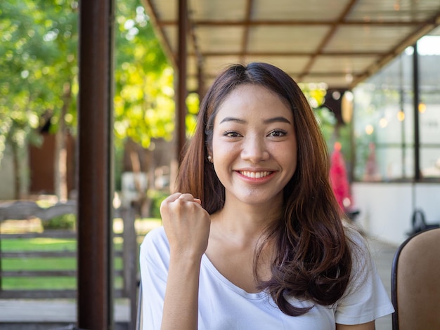 Une femme asiatique brillante et confiante avec un sourire frais Un jeune blogueur regarde la caméra pour une vidéoconférence ou une revue de produit via Internet