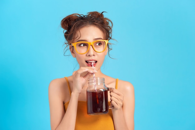 Photo femme asiatique buvant une boisson gazeuse avec une paille