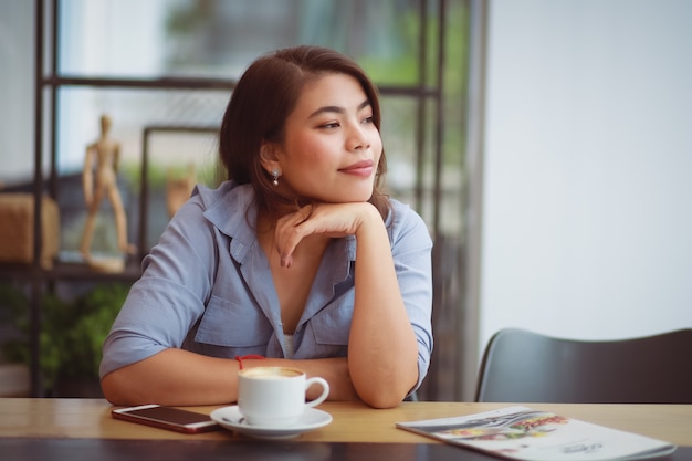 Femme asiatique, café buvant, dans, café-restaurant, café, et, utilisation, téléphone portable