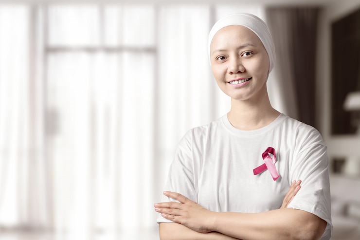 Photo femme asiatique en chemise blanche avec un ruban rose à la maison