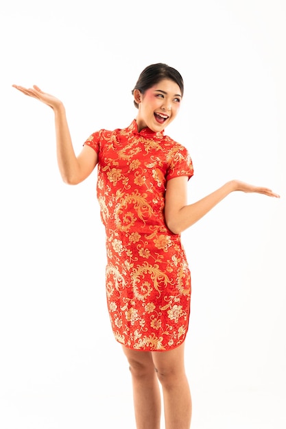 Femme asiatique en cheongsam rouge debout et lève les mains