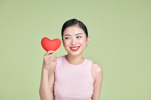 Femme asiatique avec coeur rouge sur fond blanc