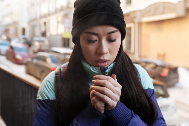 Femme asiatique congelée dans des vêtements chauds