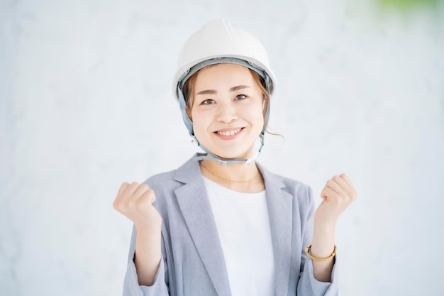 Femme asiatique en costume portant un casque à l'intérieur