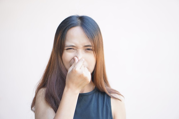 Femme asiatique couvrant son nez avec ses mains en raison d'une mauvaise odeur