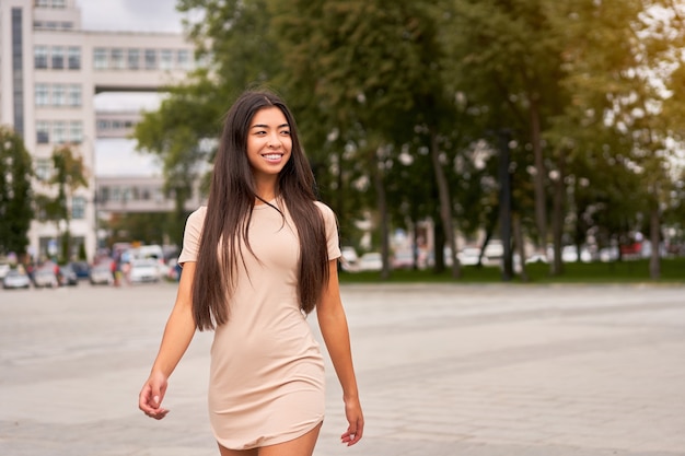 Femme asiatique dans une robe beige à l'extérieur