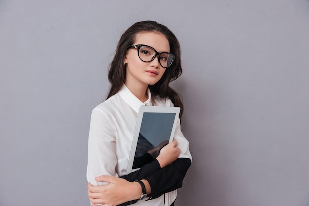 Femme asiatique dans des verres avec tablet computer hugging isolated on gray