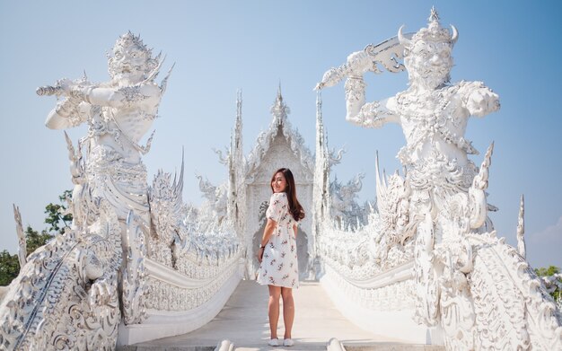 Une femme asiatique debout devant le Wat Rong Khun, le temple blanc de Chiang Rai, Thaïlande