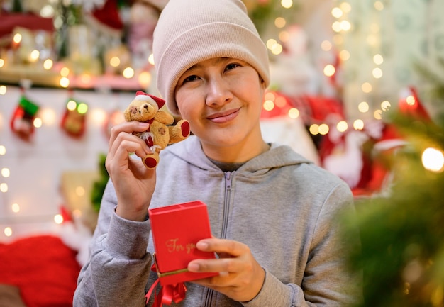 Une femme asiatique décore pour Noël seule à la maison. Fête de la famille et bonne année à la maison.