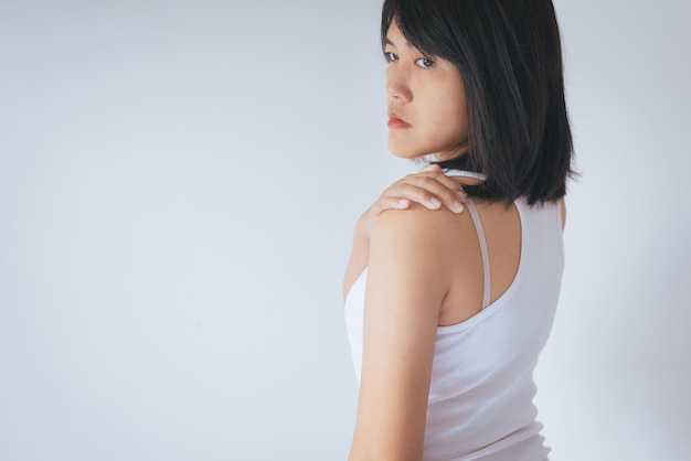 Femme asiatique avec douleur à l'épaule Main féminine la touchant douloureusement