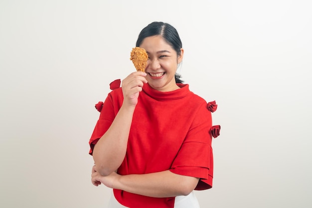 Femme asiatique avec du poulet frit à portée de main