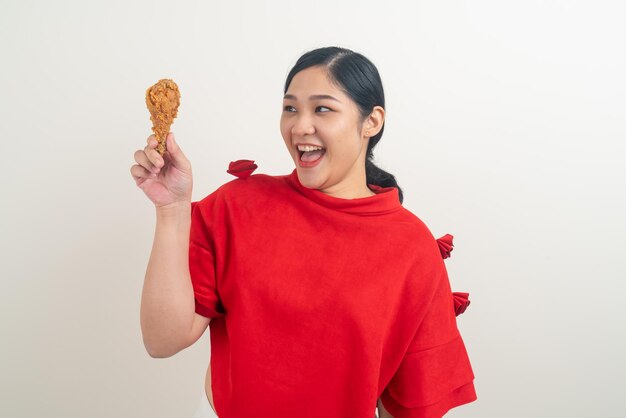 Femme asiatique avec du poulet frit à portée de main