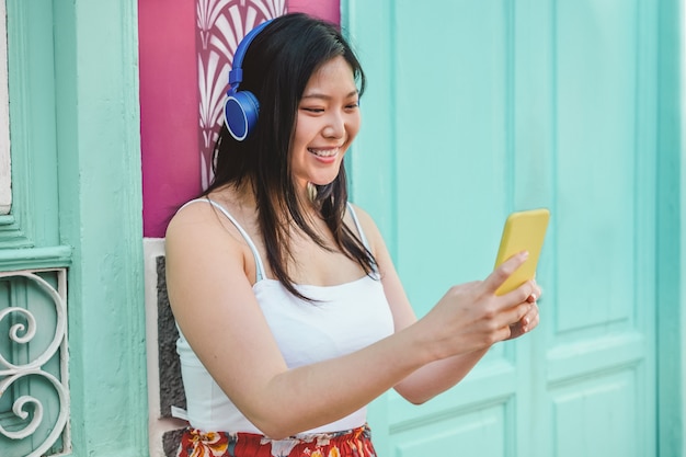 Femme asiatique, écouter de la musique avec l'application smartphone en plein air