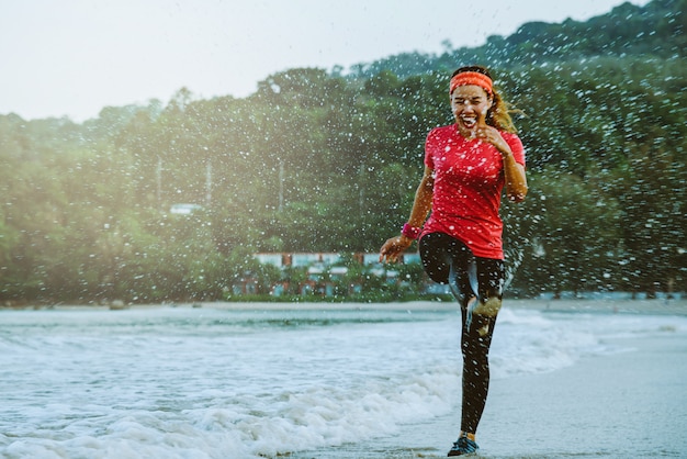 Femme asiatique, entraînement de jogging sur la plage le matin.