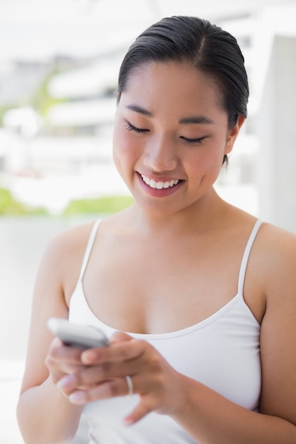 Femme asiatique, envoyer des SMS sur le téléphone