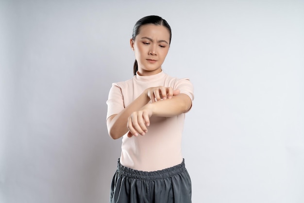 Femme asiatique était malade avec des démangeaisons irritées sa peau debout isolé sur fond blanc