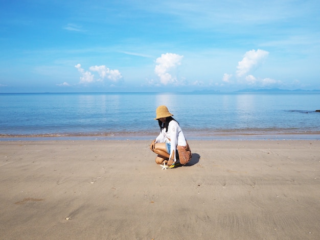Femme asiatique et étoile de mer sur fond de plage de l&#39;été.