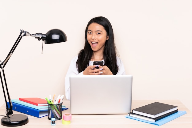 Femme asiatique étudiante dans un lieu de travail avec un ordinateur portable isolé