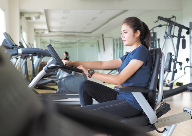 Femme Asiatique, Faire Du Vélo Stationnaire Dans La Salle De Gym.