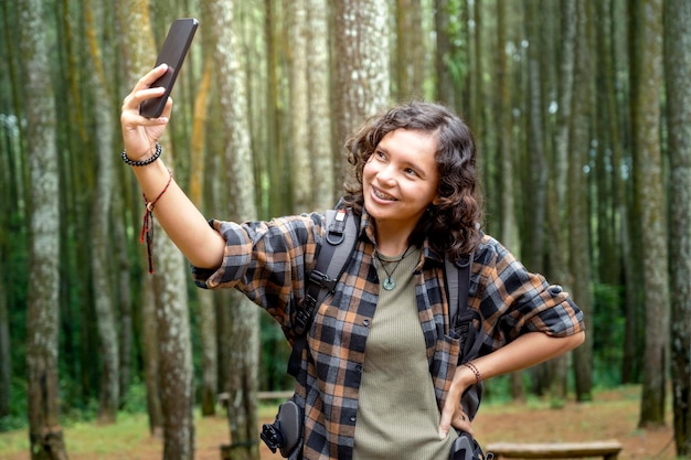 Femme asiatique faisant du trekking et prenant des autoportraits dans la forêt