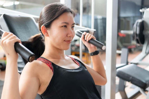 Femme asiatique faisant de l'exercice Entraînement de poids au gymnase Concept de remise en forme et de soins de santé